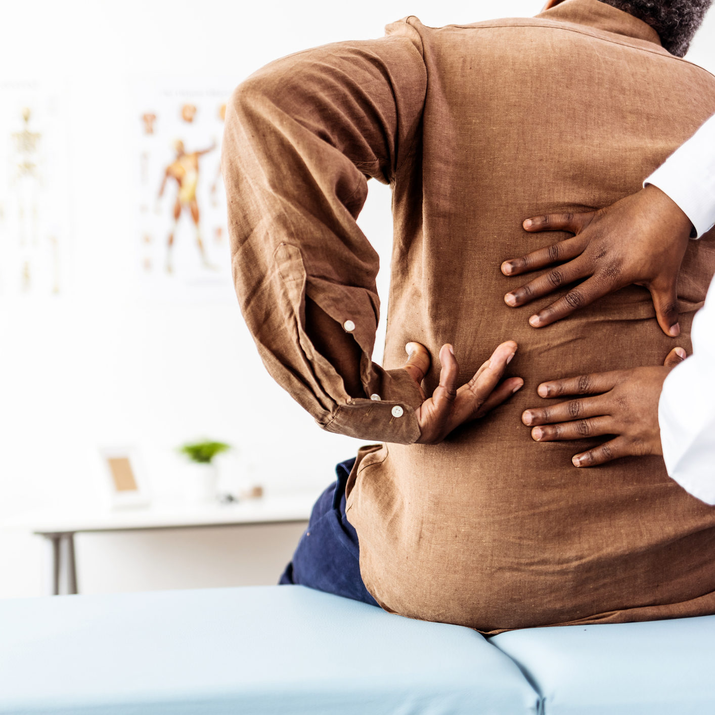 Doctor physiotherapist doing healing treatment on man's bac
